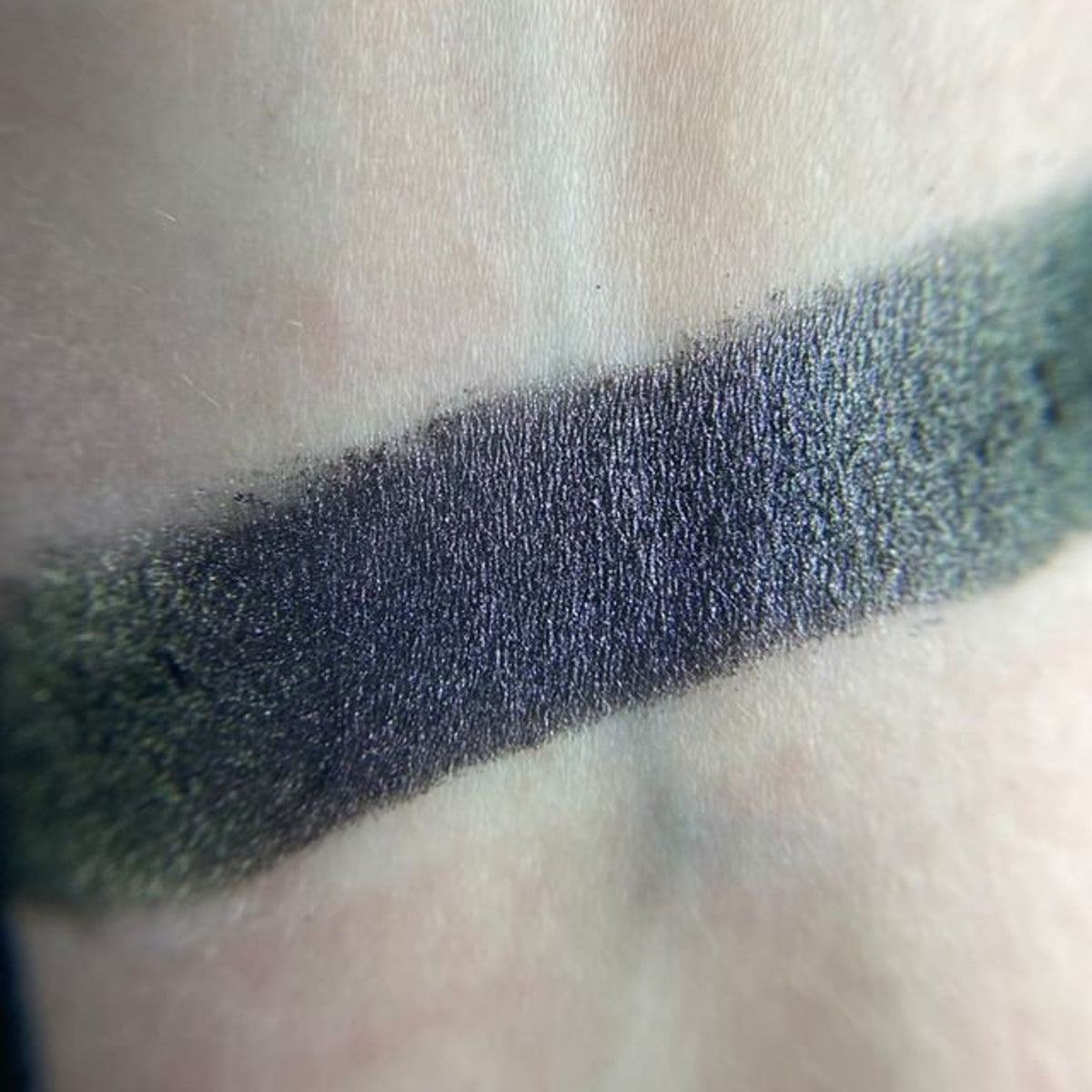 Close-up of a sleek black compact eye shadow palette with shimmering neutral-toned powders