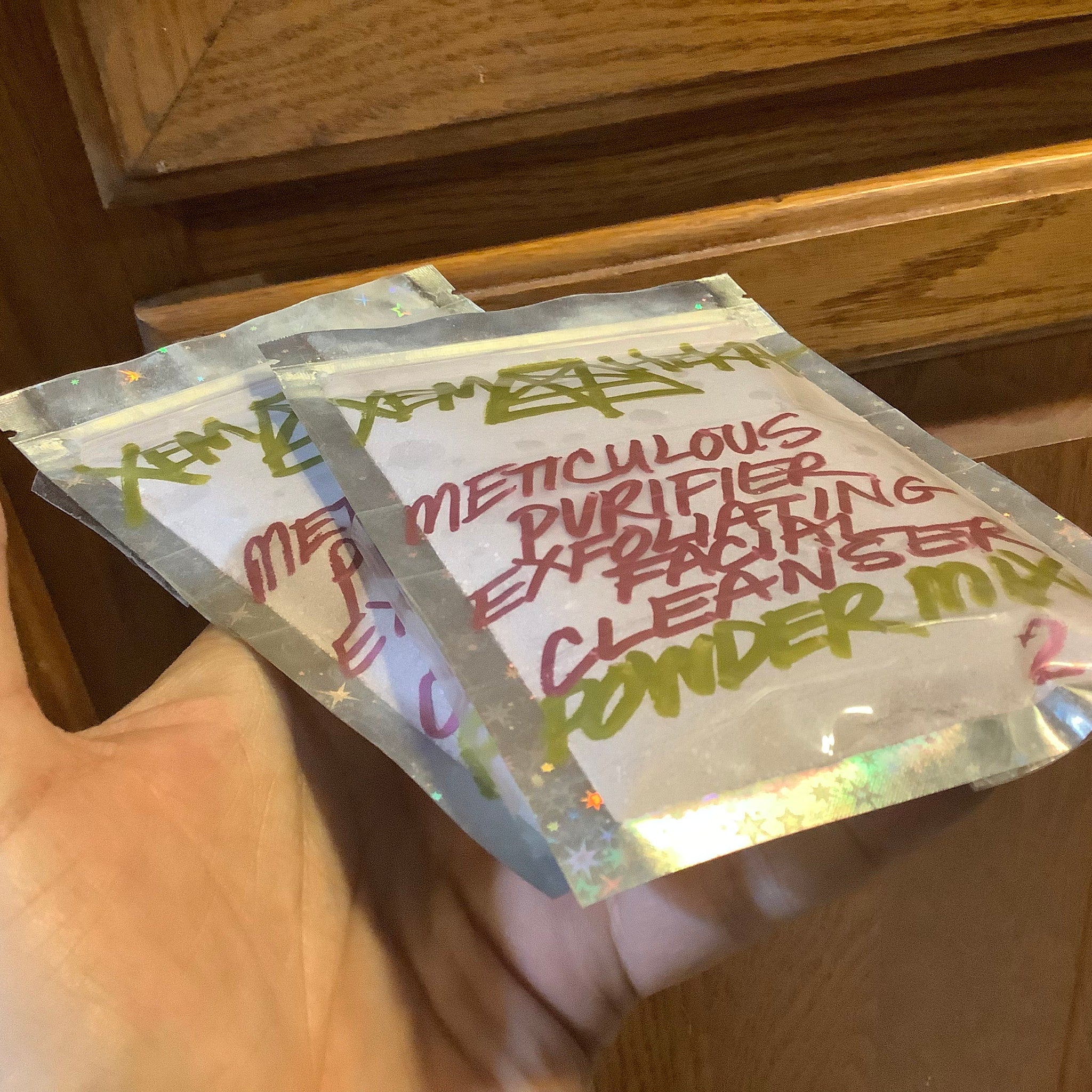 Purifying powder packets in clear iridescent plastic with handwritten text in green and red