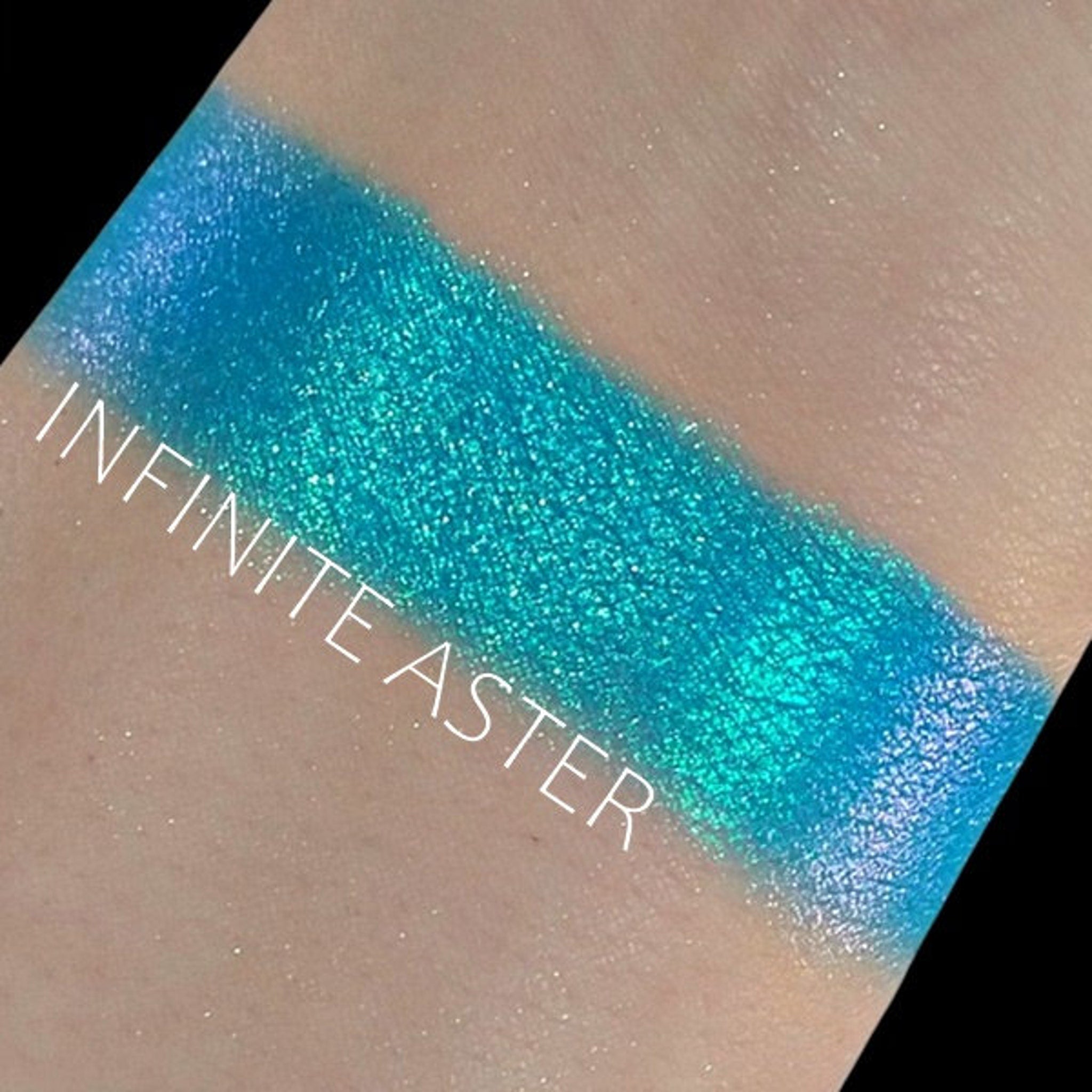 Close-up of Duochrome Shifting Eye Shadow in Infinite Aster showing iridescent purple-to-blue color shift in compact pan.