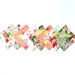 Coasters with floral and solid patterns in pink, green, white, and yellow colors, arranged in a row