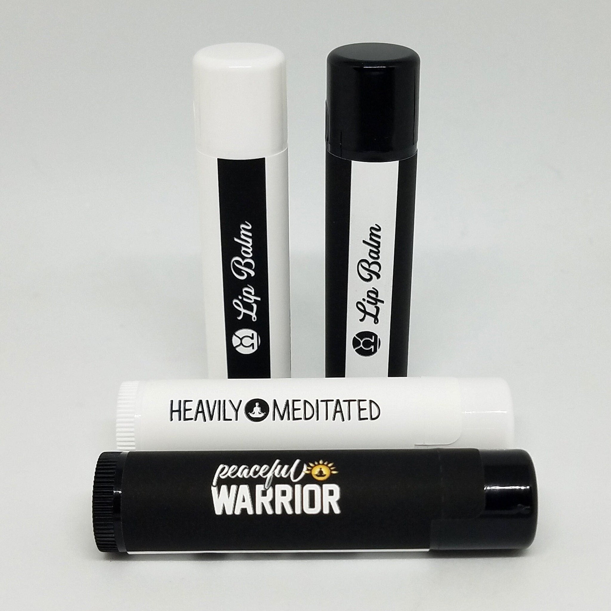 Lip balm tubes in black and white with text "Lip Balm" and "peaceful WARRIOR" displayed