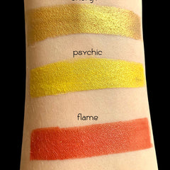 Close-up of loose vegan gold mineral eyeshadow with shimmering metallic particles in a glass jar