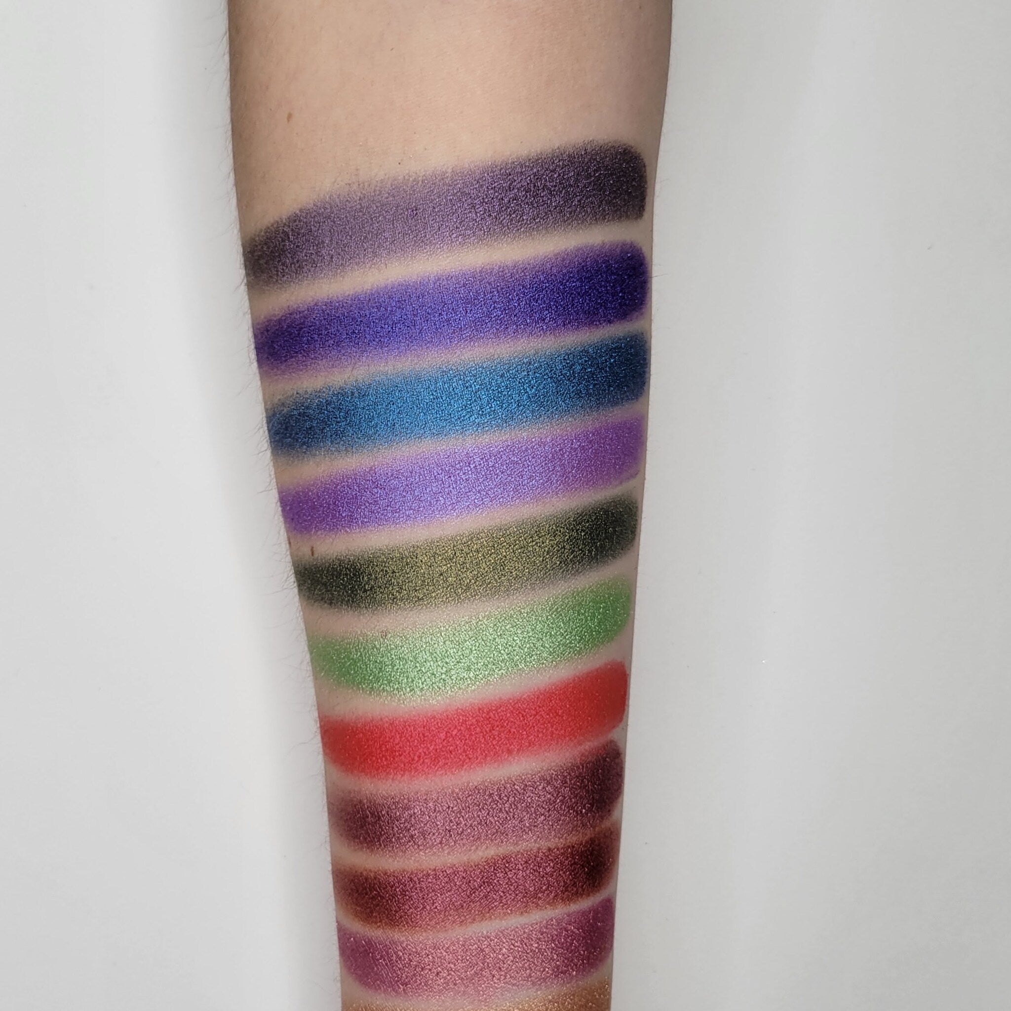 Swatch of Gracidea Hot Pink Red eyeshadow showing vibrant color payoff on fingertip