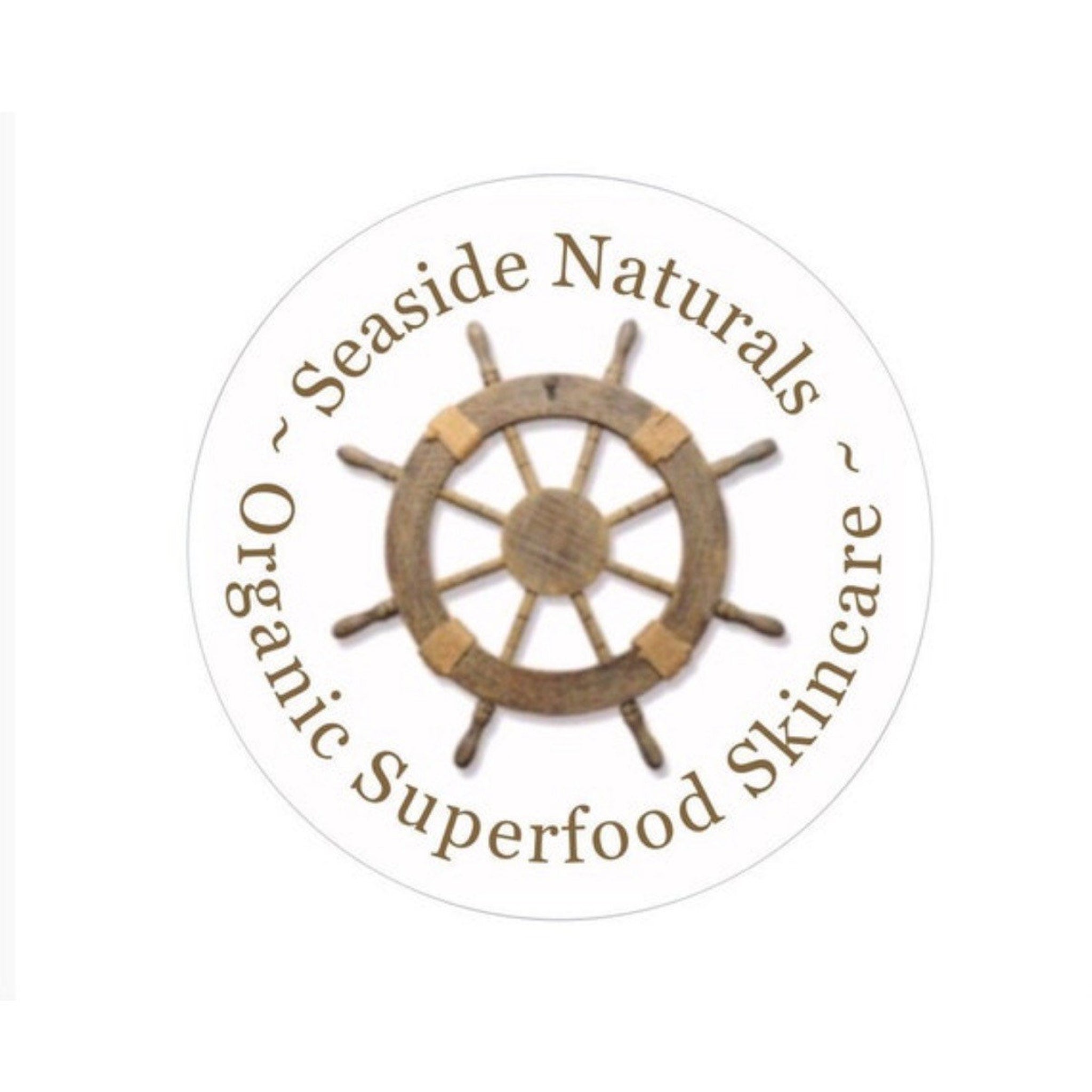 Seaside Naturals logo with wooden ship wheel and brown text on white background