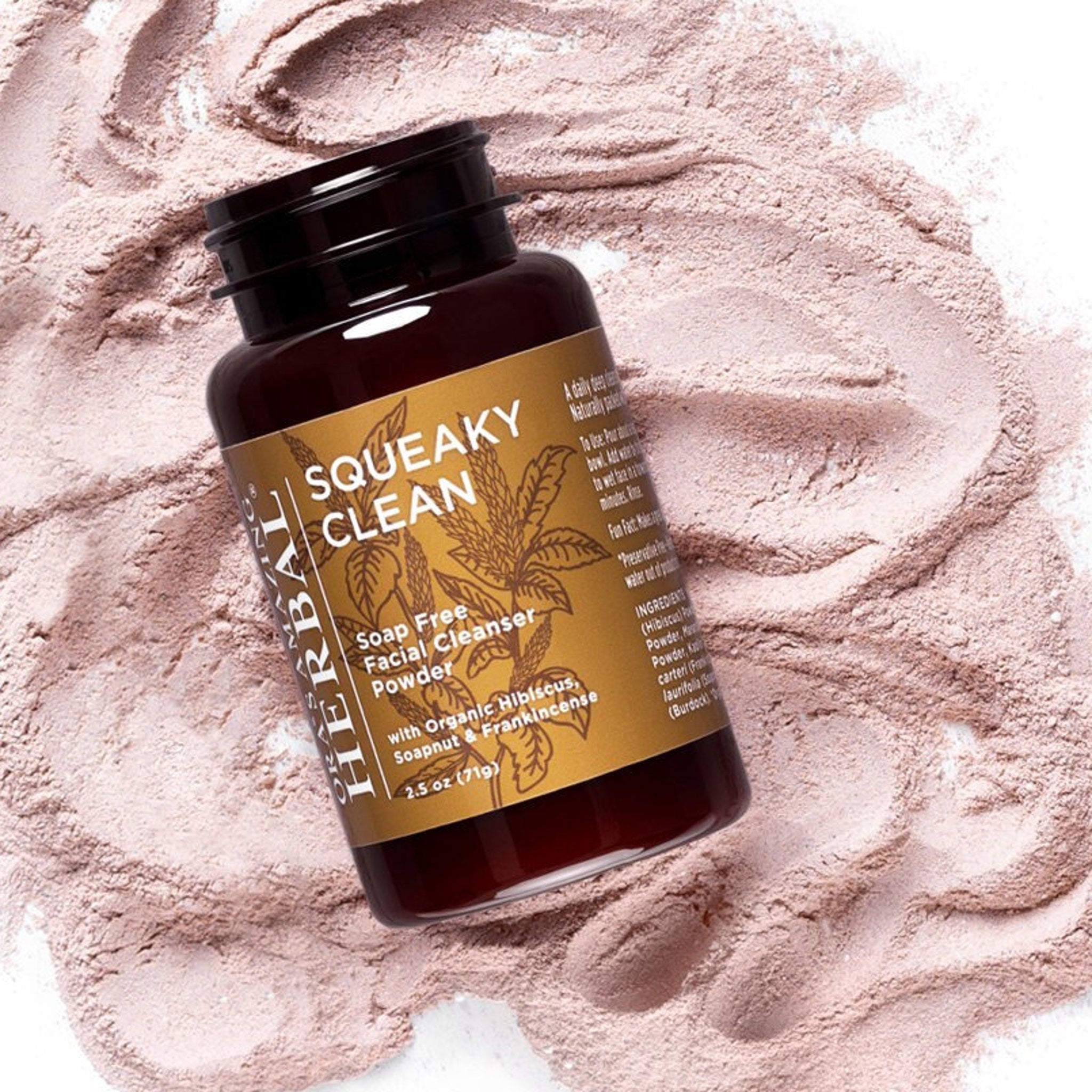 Facial cleanser powder with brown bottle, gold label, and pink powder background