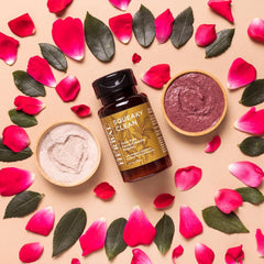Face powder with pink petals, green leaves, and Ora's Amazing Herbal bottle on beige surface