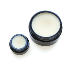 Side view of organic vanilla butter moisturizer in a sleek white tube with gold accents, showcasing silky texture