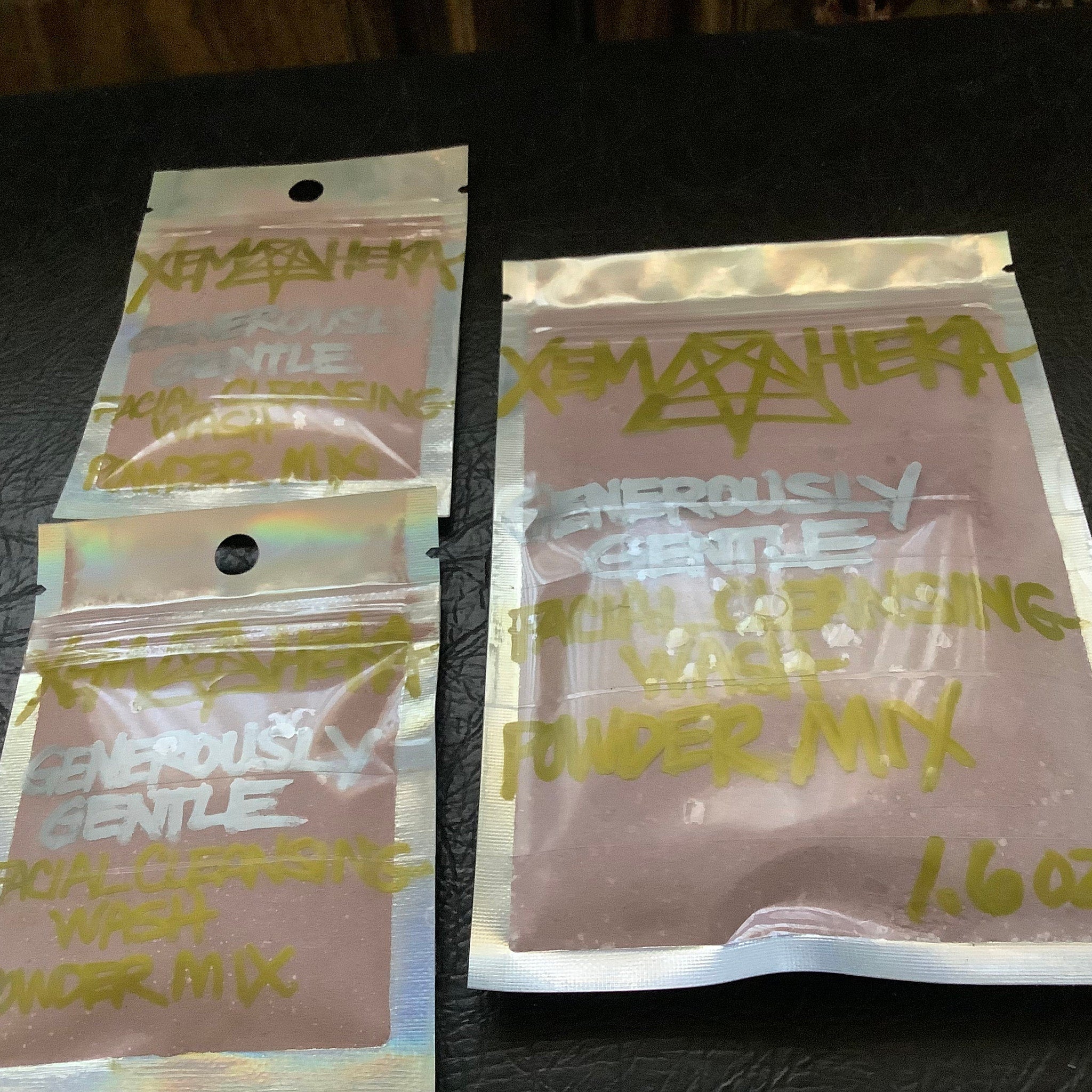 Facial cleansing powder mix in clear plastic pouches with pink powder and handwritten text