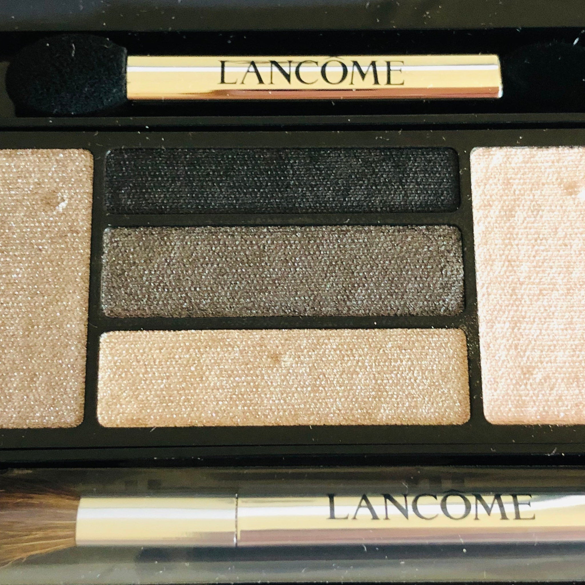 Side view of LANCÔME x Alber Elbaz eye shadow palette showcasing blue and taupe shades in sleek black packaging
