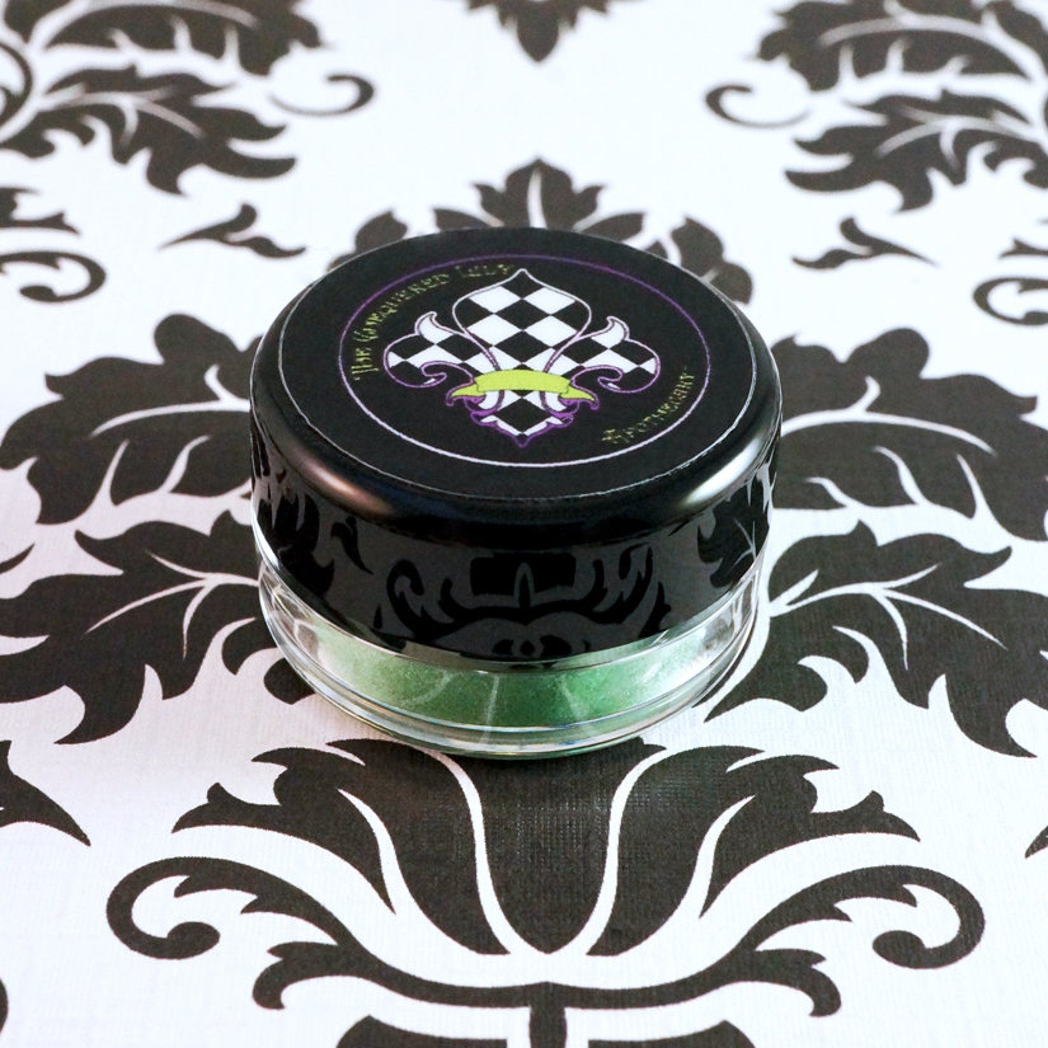 Swatch of metallic lime green loose eyeshadow pigment with iridescent candy apple sheen on fingertip