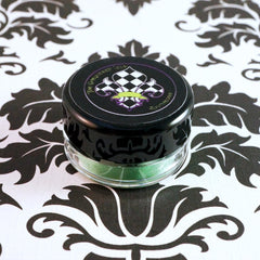 Swatch of metallic lime green loose eyeshadow pigment with iridescent candy apple sheen on fingertip