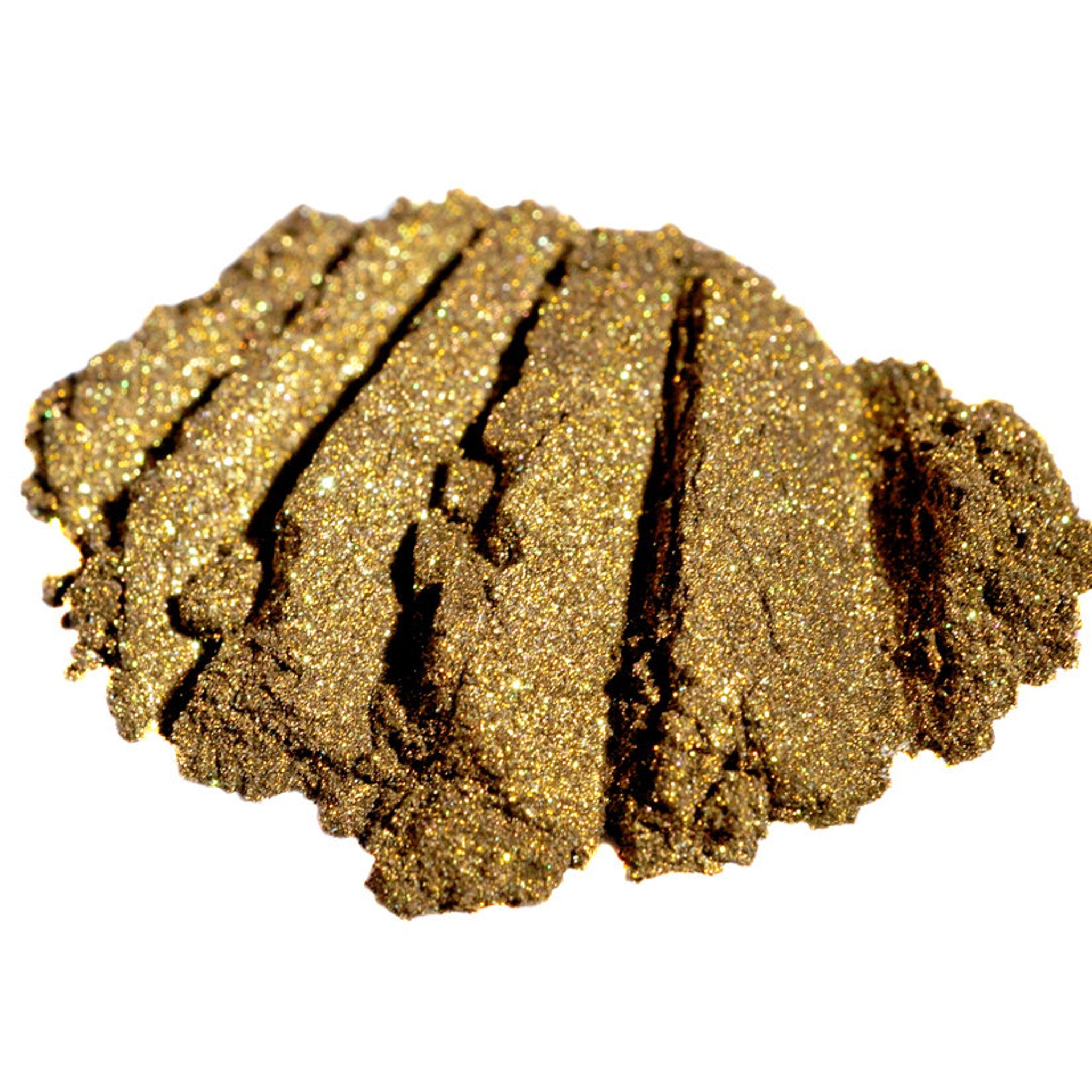 Hand applying metallic bronze loose eyeshadow with dark gold base and green glitter using a makeup brush