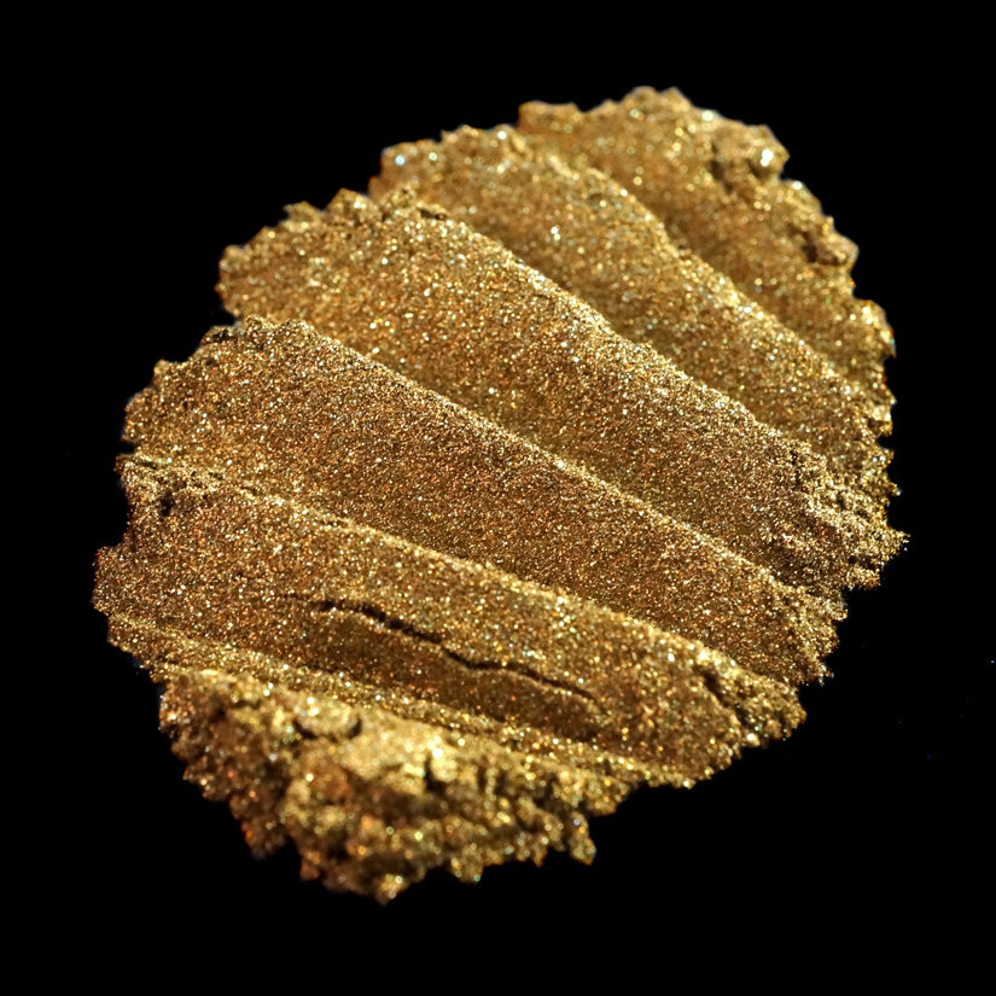 Metallic bronze loose eyeshadow in dark gold with vibrant green glitter particles, vegan Halloween makeup