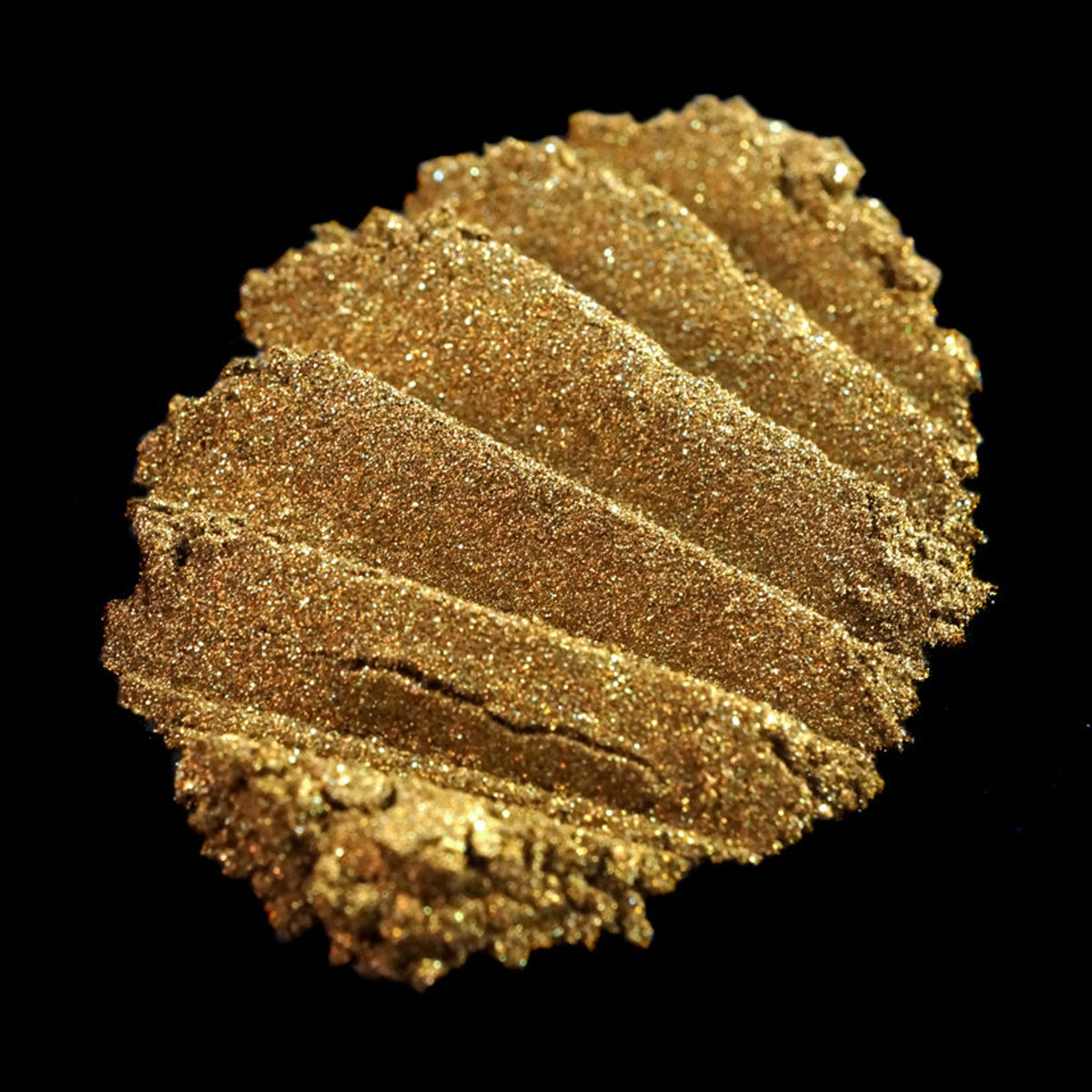 Metallic bronze loose eyeshadow in dark gold with vibrant green glitter particles, vegan Halloween makeup