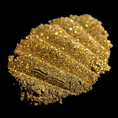 Side view of loose metallic bronze eyeshadow jar showing dark gold powder with green glitter flecks