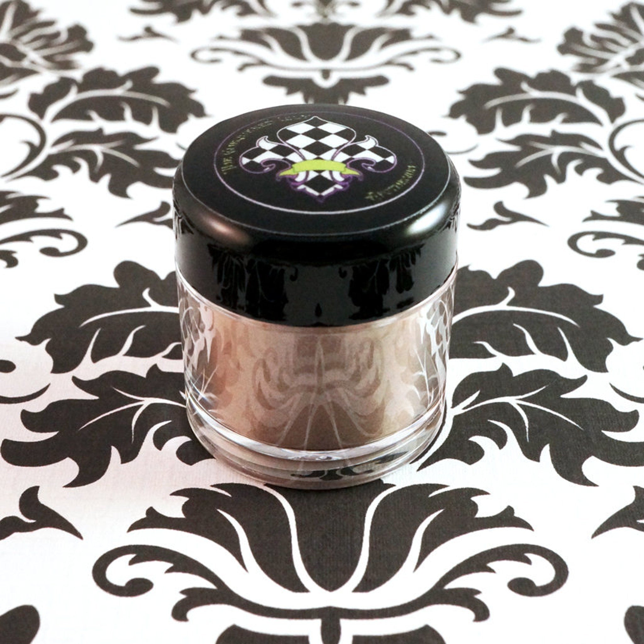 Side view of loose pigment eyeshadow in metallic taupe and champagne with silver shimmer, showcasing texture