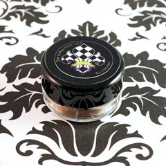 Swatch of metallic taupe and champagne loose pigment eyeshadow with silver shimmer on fingertip