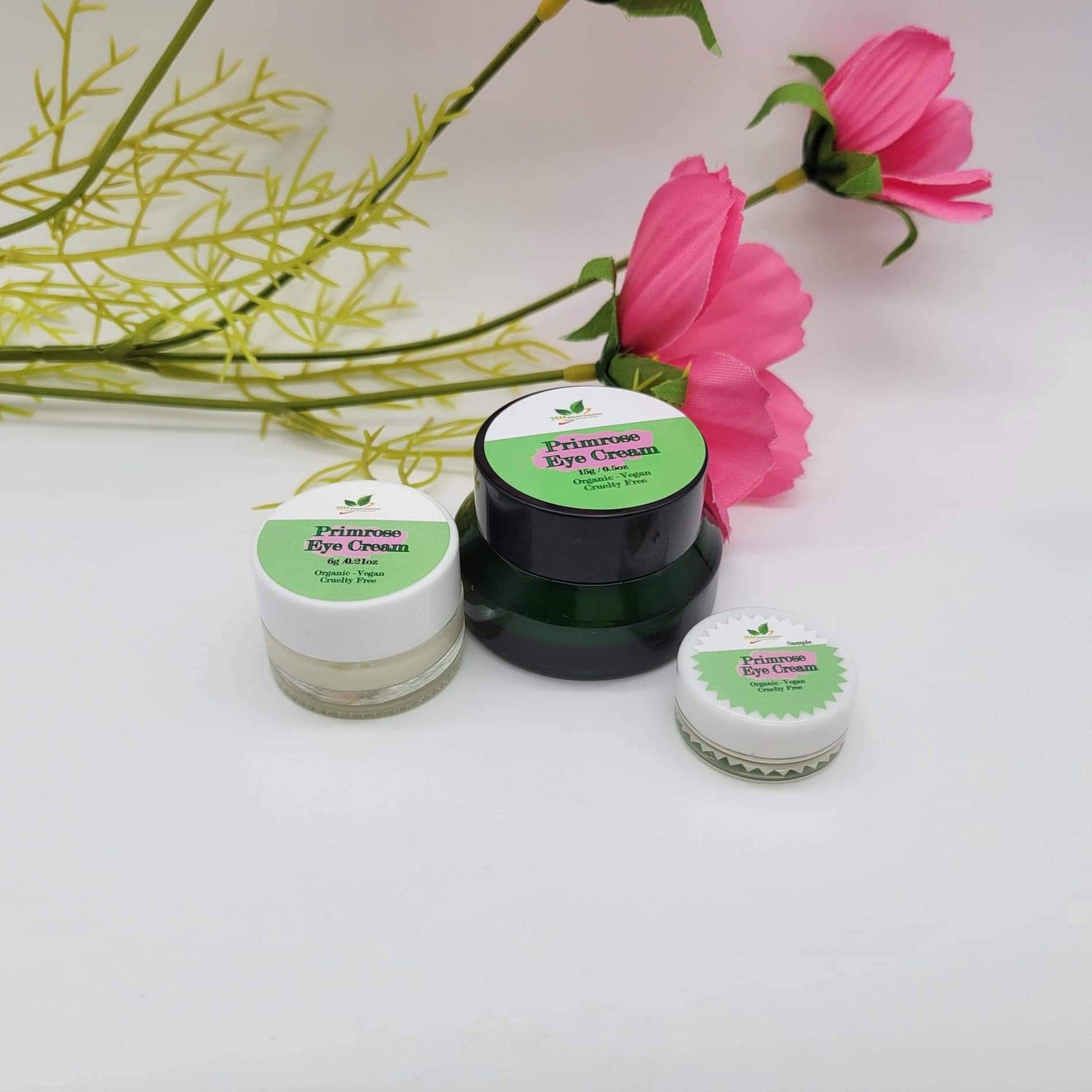 Eye cream jars with white, green, and black lids, with Primrose Eye Cream label visible