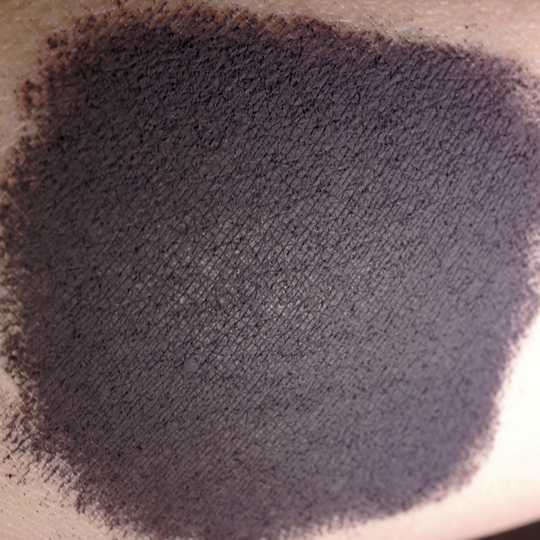 Side view of matte dark purple loose mineral eyeshadow in an open jar showing rich aubergine pigment texture