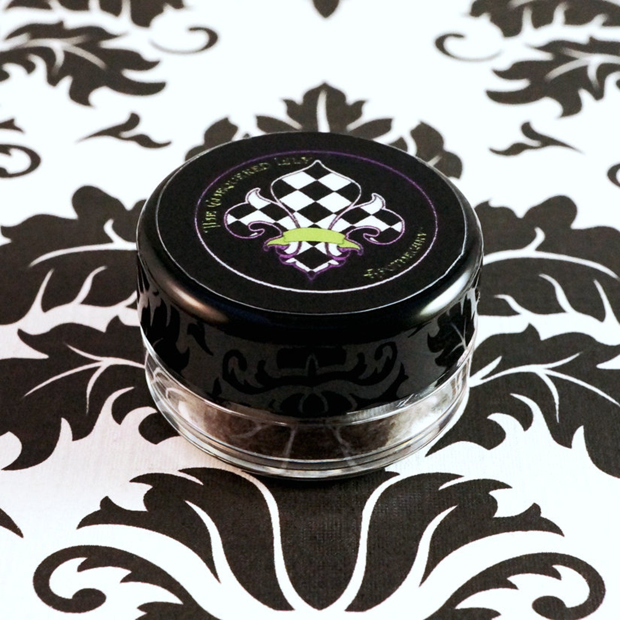 Dark purple-gray matte loose pigment eyeshadow dusted on fingertips with violet undertones
