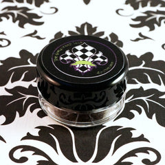 Dark purple-gray matte loose pigment eyeshadow dusted on fingertips with violet undertones