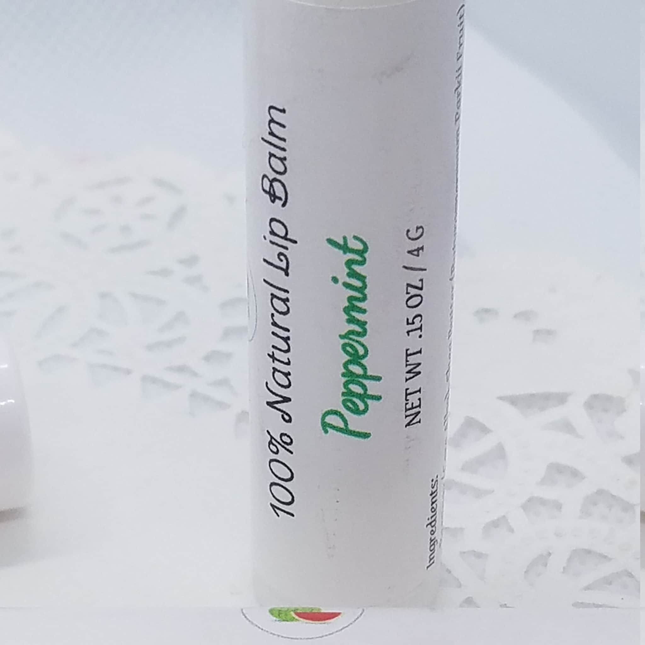 Lip balm tube with white label, green "Peppermint" text, and black text detail