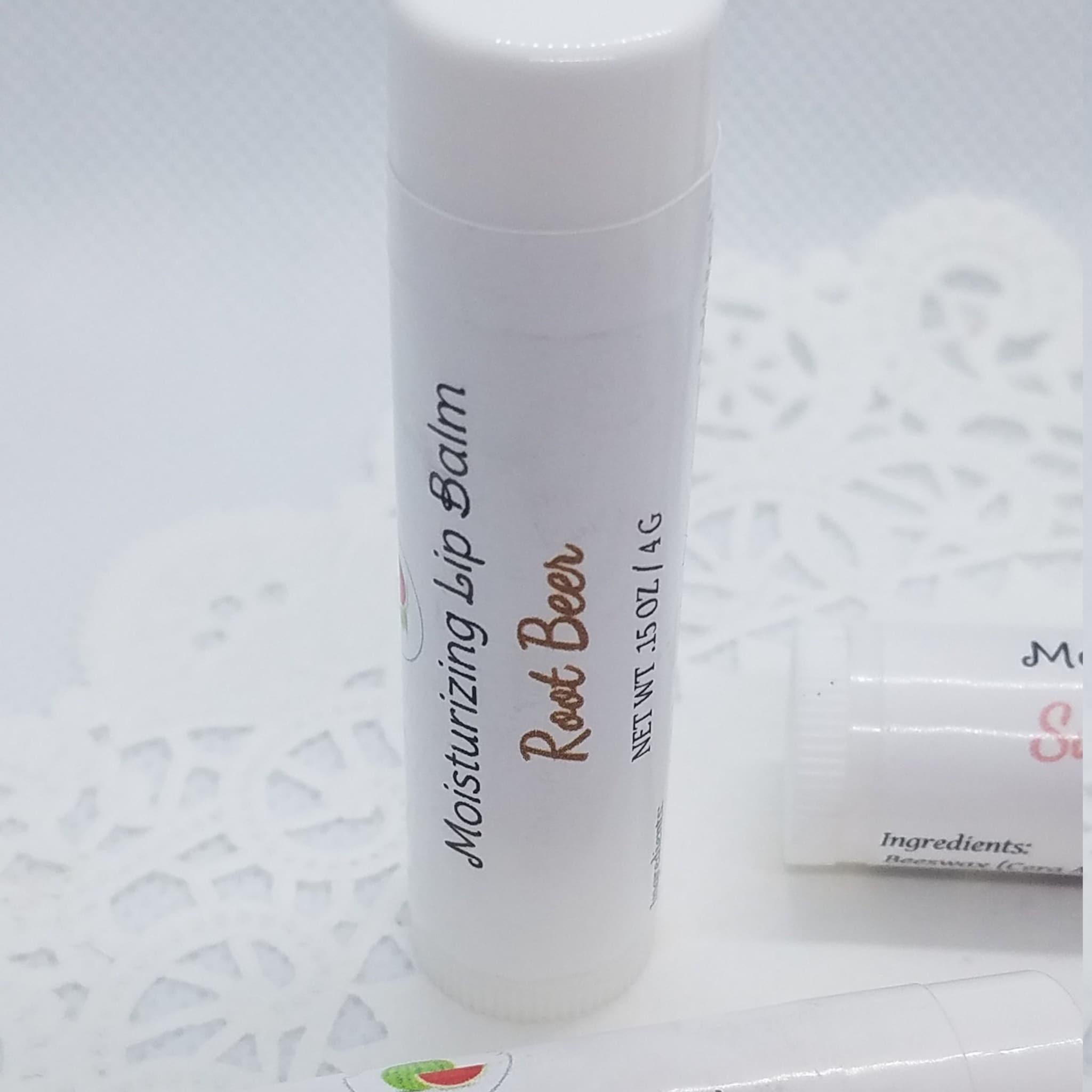 Lip balm tube with white label, "Root Beer" text, and Mellen Patch Soaps branding