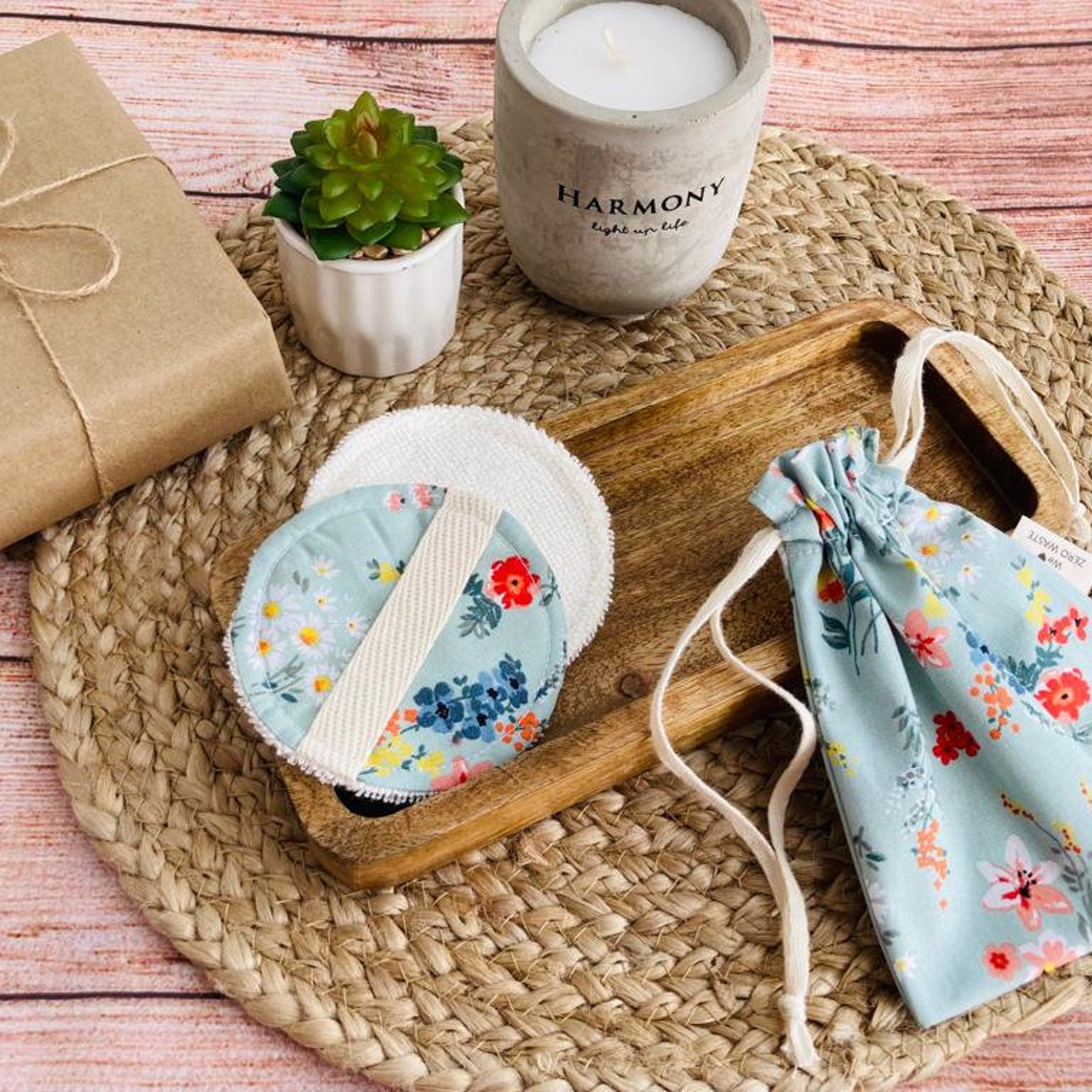 Reusable makeup remover pads with floral pattern, white terrycloth, and drawstring bag on woven mat