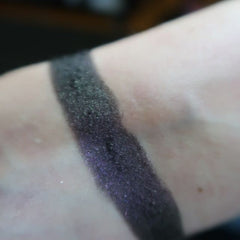 Side view of matte taupe eye shadow compact with sleek black case and mirrored interior