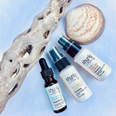 Skincare products with white bottles, black caps, and Shunly branding on white background
