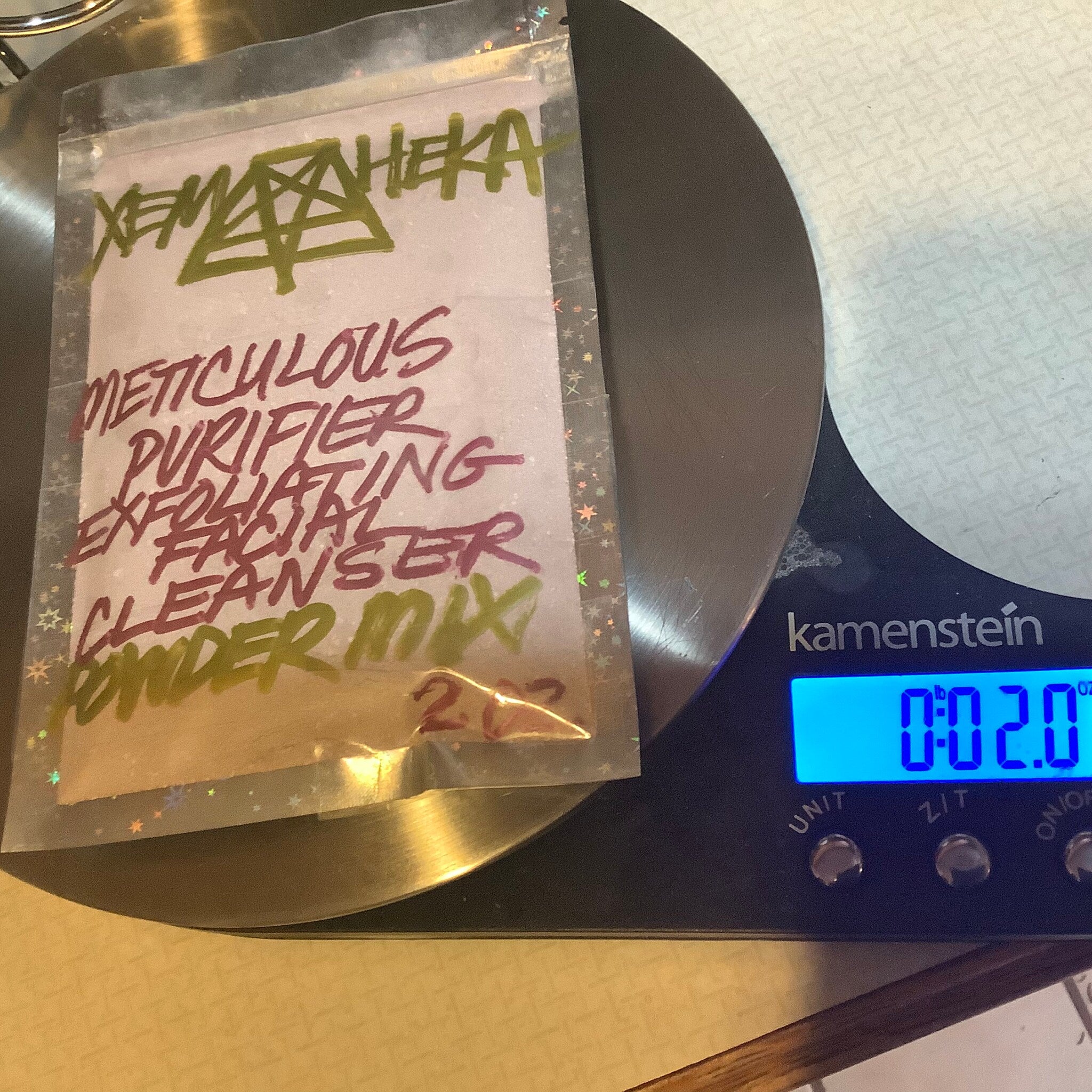 Powder mix bag with pink text on clear plastic, on a digital scale, reading 0.2 oz