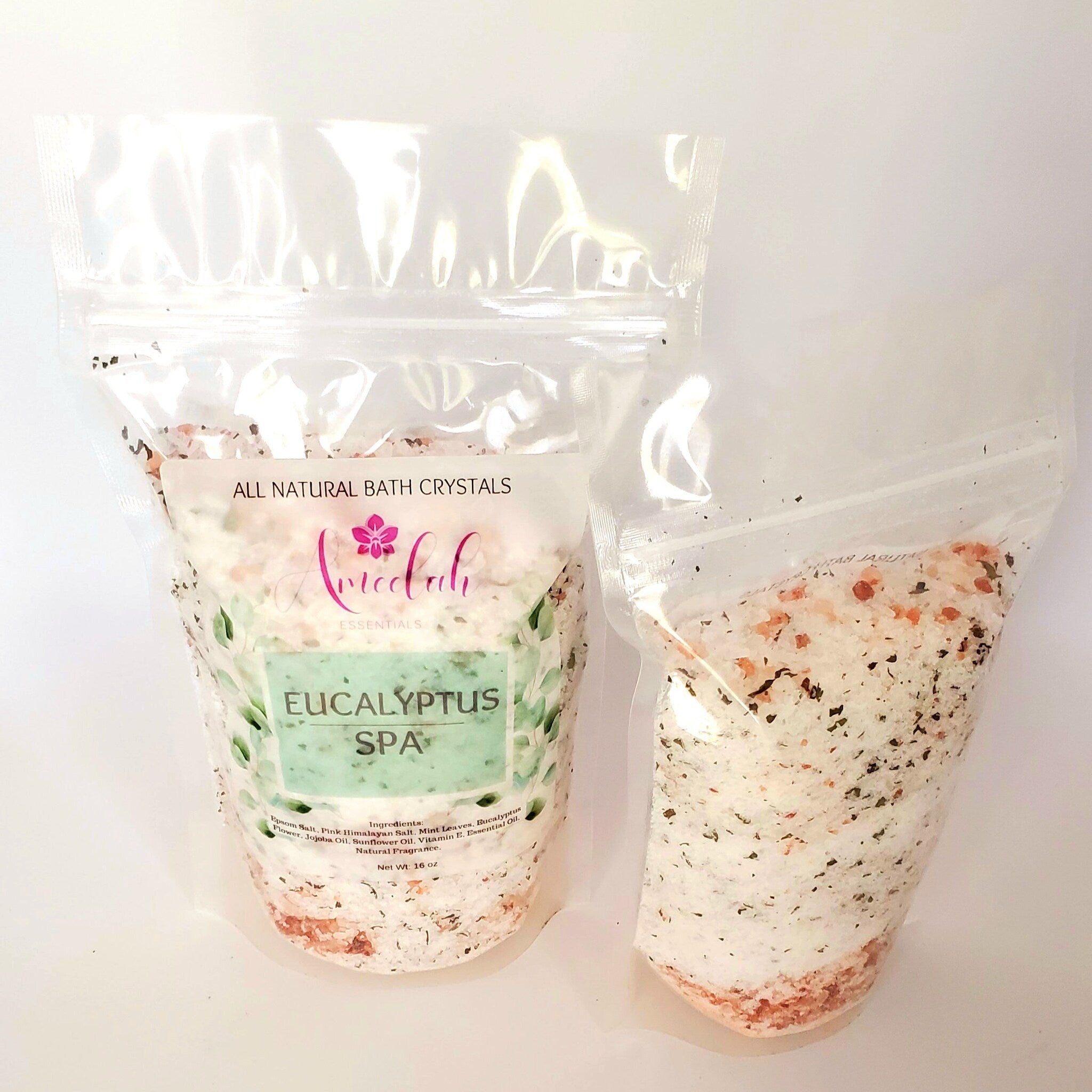 Bath crystals in clear plastic bags with white, pink, and green granules, "Annedah Essentials" brand visible