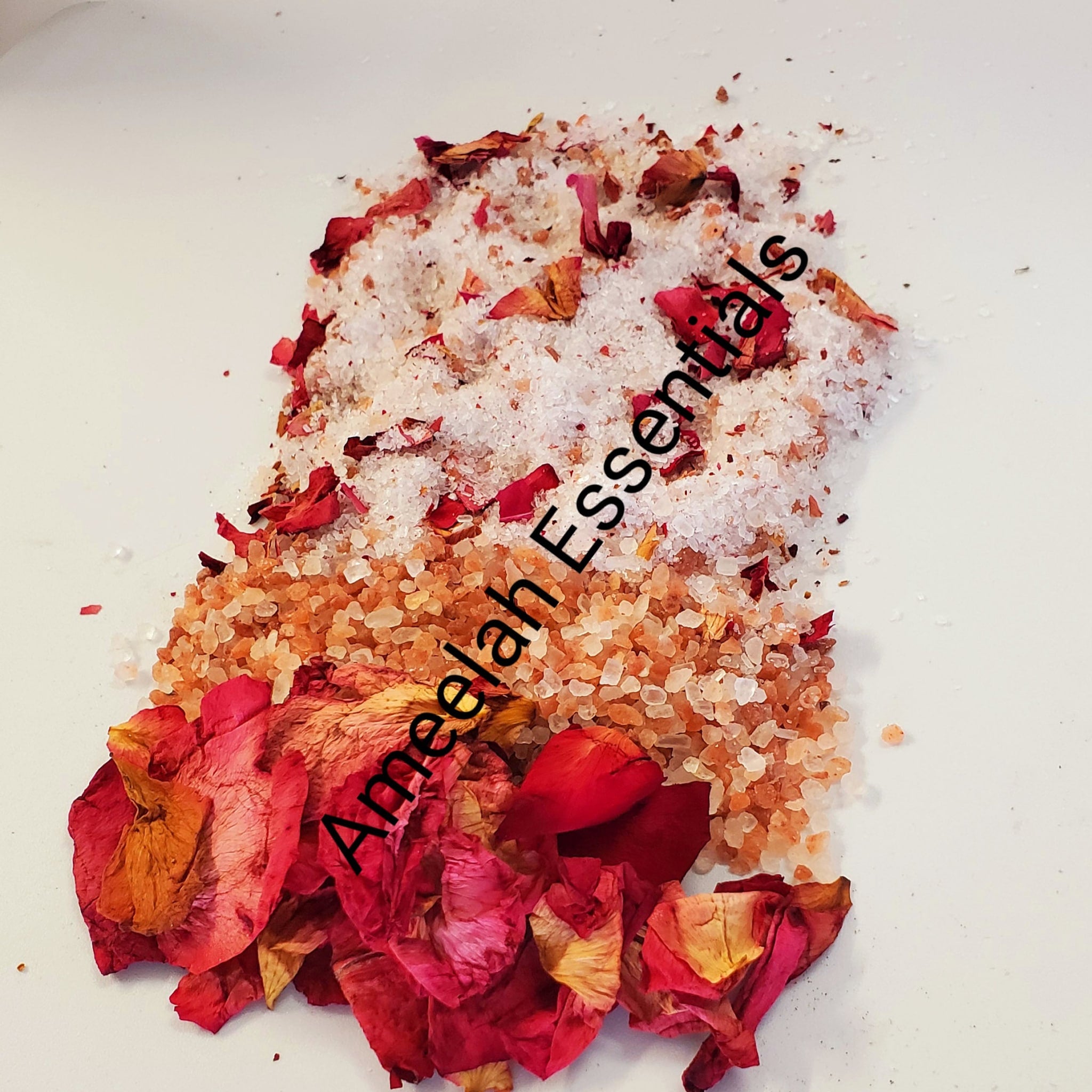 Bath salts with red rose petals, white and orange crystals, Ameelah Essentials brand text visible