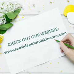 White paper with green text, pencil, and floral accents on a white wood surface, seaside naturals website