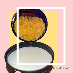 Turmeric scrub in open black jar, with yellow granules and white cream visible