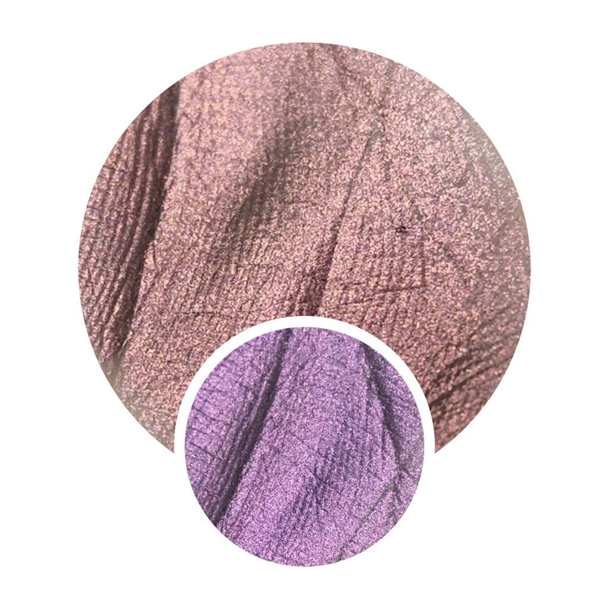 Pressed multichrome eyeshadow pan shifting from orange to pink with olive undertones in triangular compact