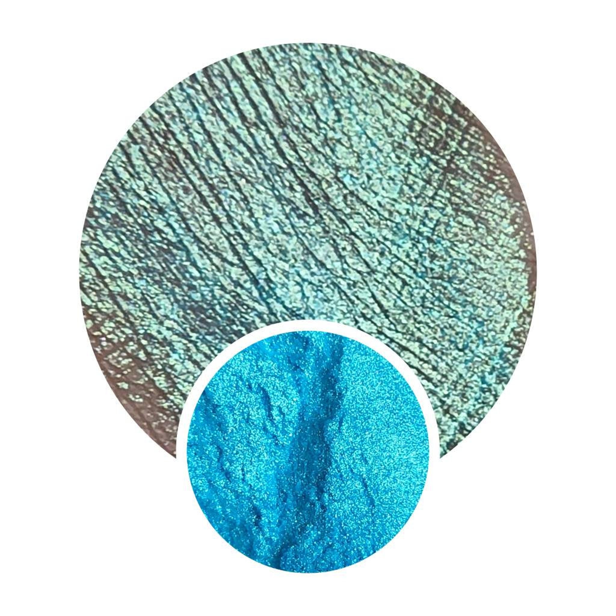 Close-up of chameleon moonshifter loose pigment in a jar showing multichrome shift from gold to pink.