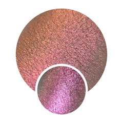 Close-up of NEBULA Collection Ceres eyeshadow pot showcasing chameleon orange-pink-gold-violet multichrome shift on smooth surface