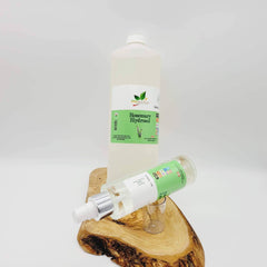 Rosemary Hydrosol bottles, clear liquid, green and white labels, on wooden surface