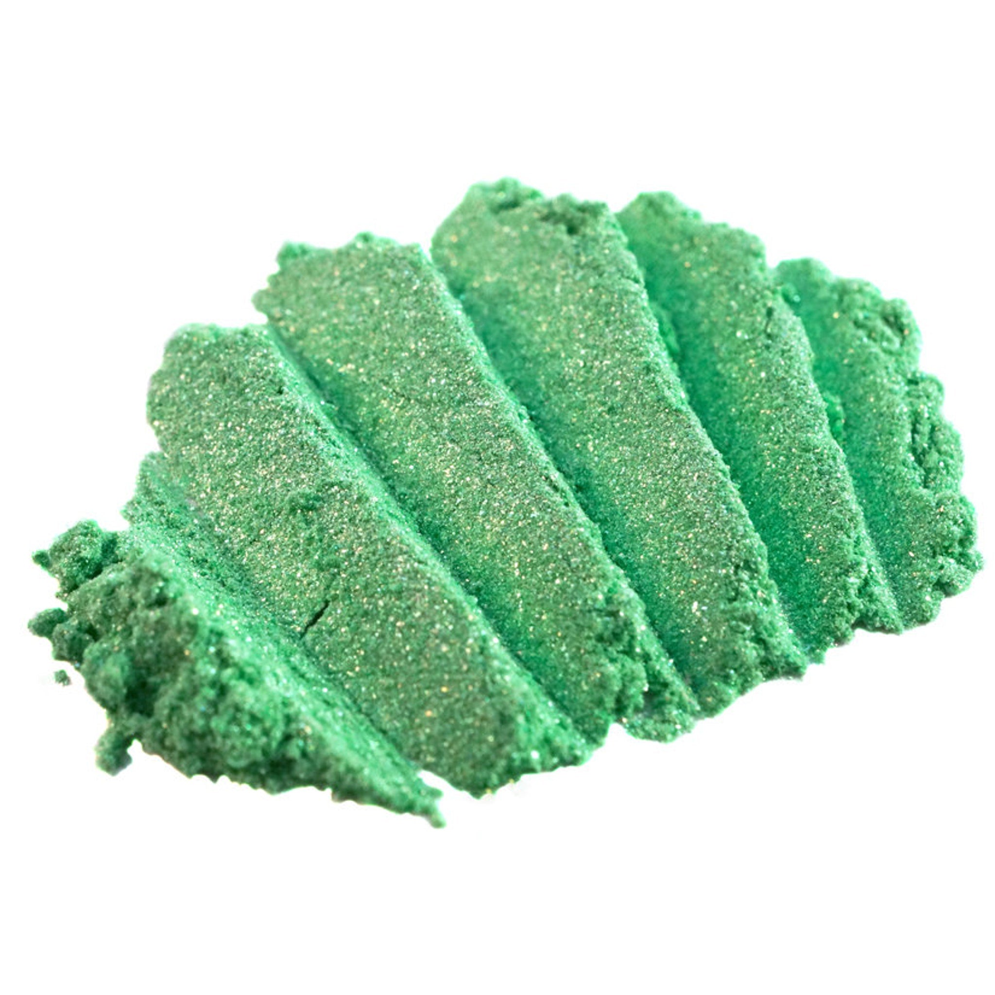 Close-up of loose iridescent lime green eyeshadow pigment with metallic candy apple sheen