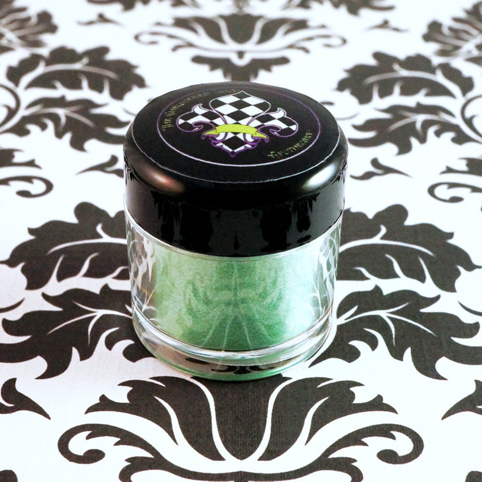 Side view of loose iridescent lime green eyeshadow pigment shimmering with metallic candy apple highlights