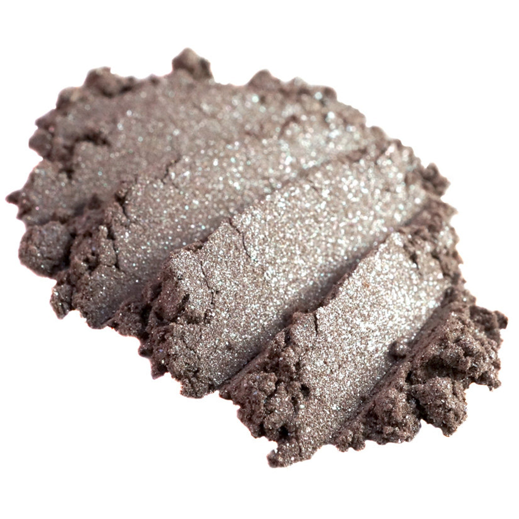 Close-up of loose metallic taupe and champagne eyeshadow pigment with silver shimmer particles scattered on skin