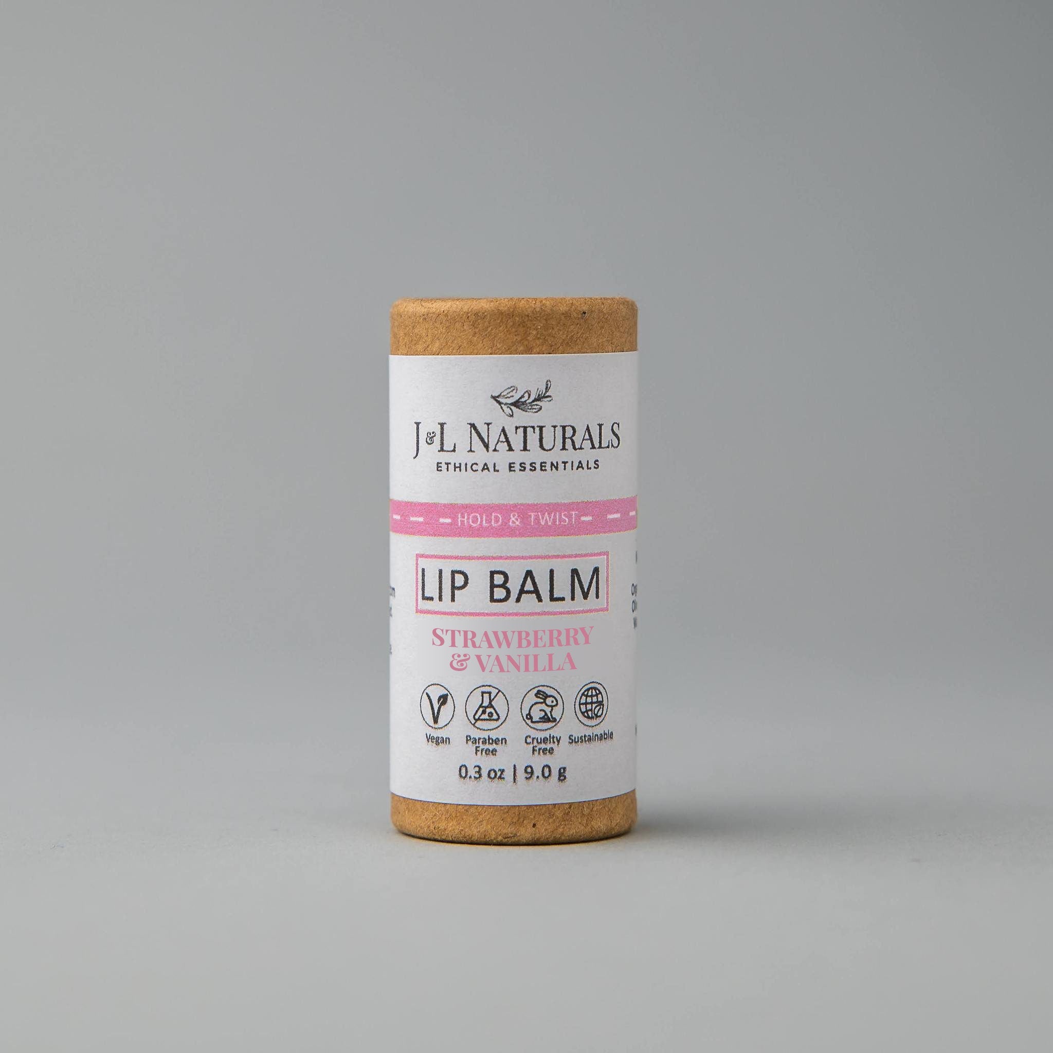 Lip balm tube with brown cardboard top, white label, and pink text, J&L Naturals brand