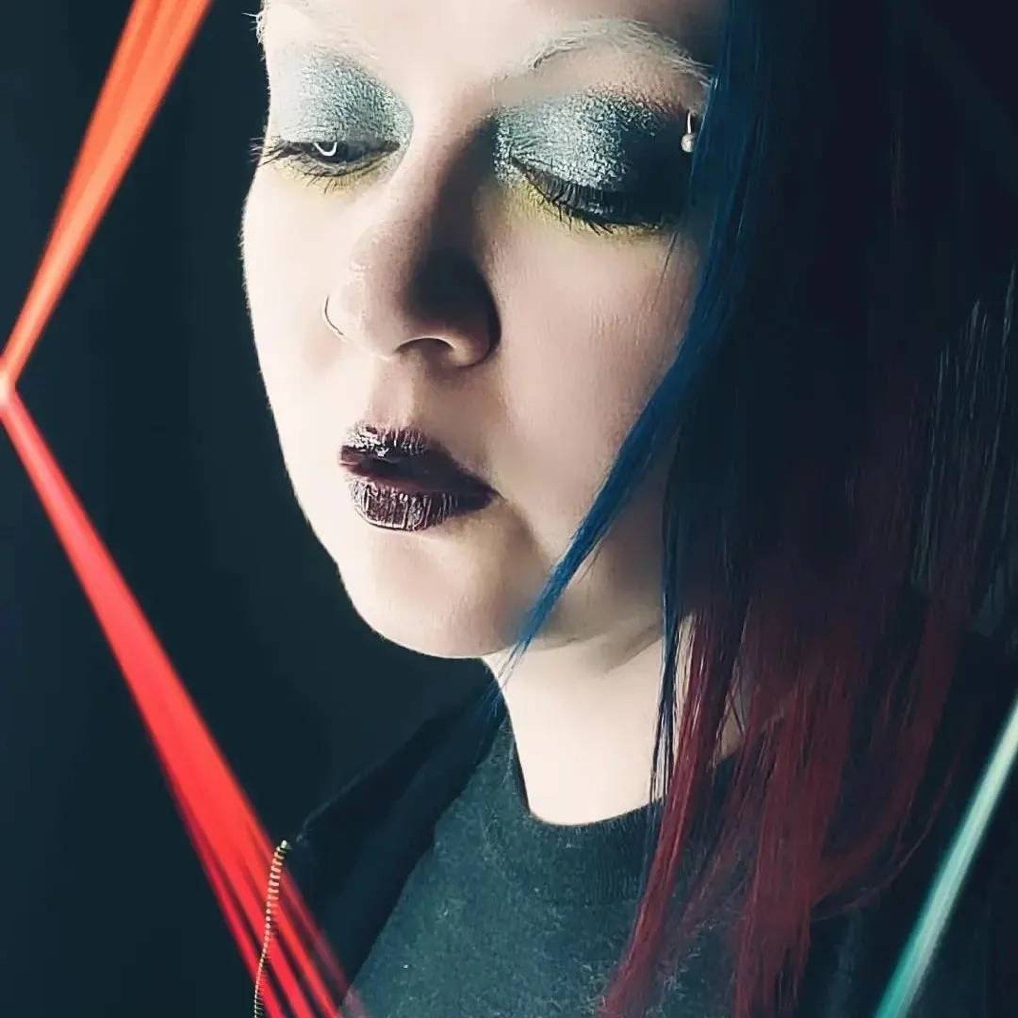 Side view of Moonrise Chameleon multichrome eye shadow pot showing icy blue to grey shift with sparkling shimmer particles