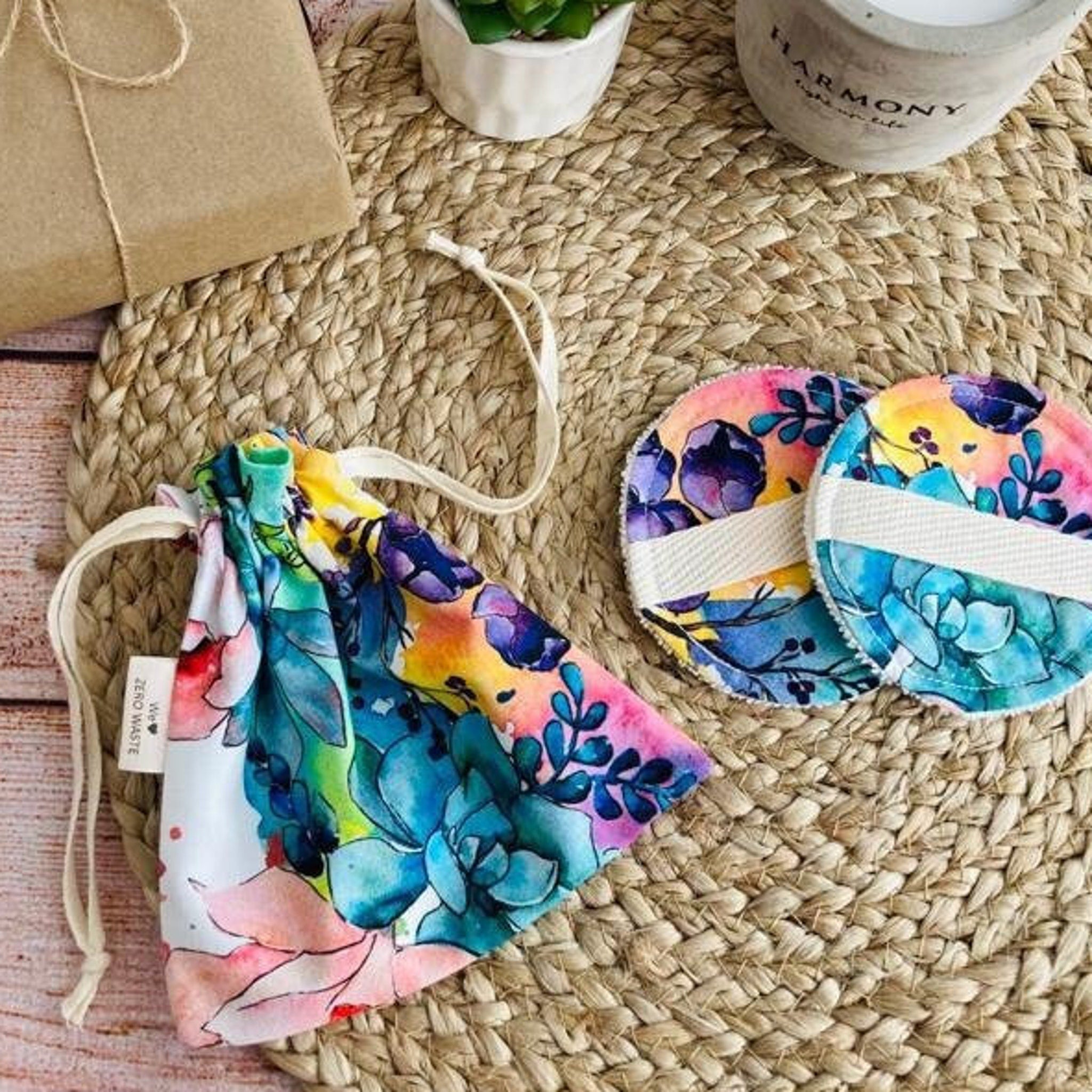 Reusable makeup remover pads with floral pattern, drawstring bag, white strap, and BloomPads text visible on bag