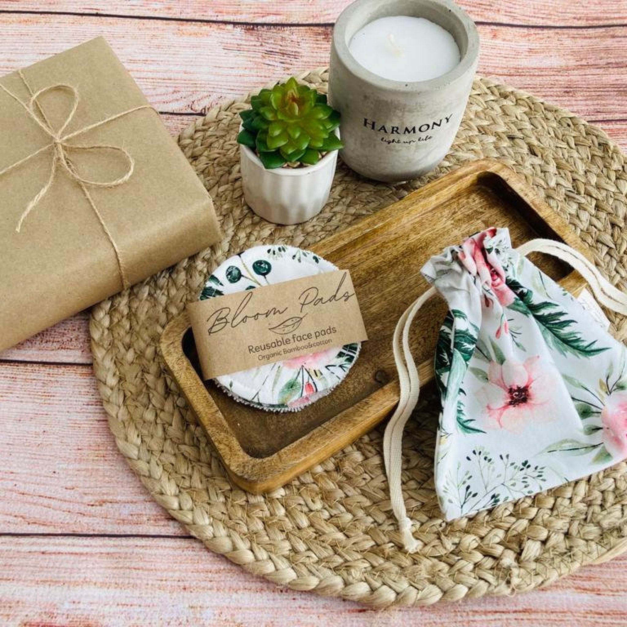 Reusable face pads with floral pattern, white and green, in wooden tray with Bloom Pads label