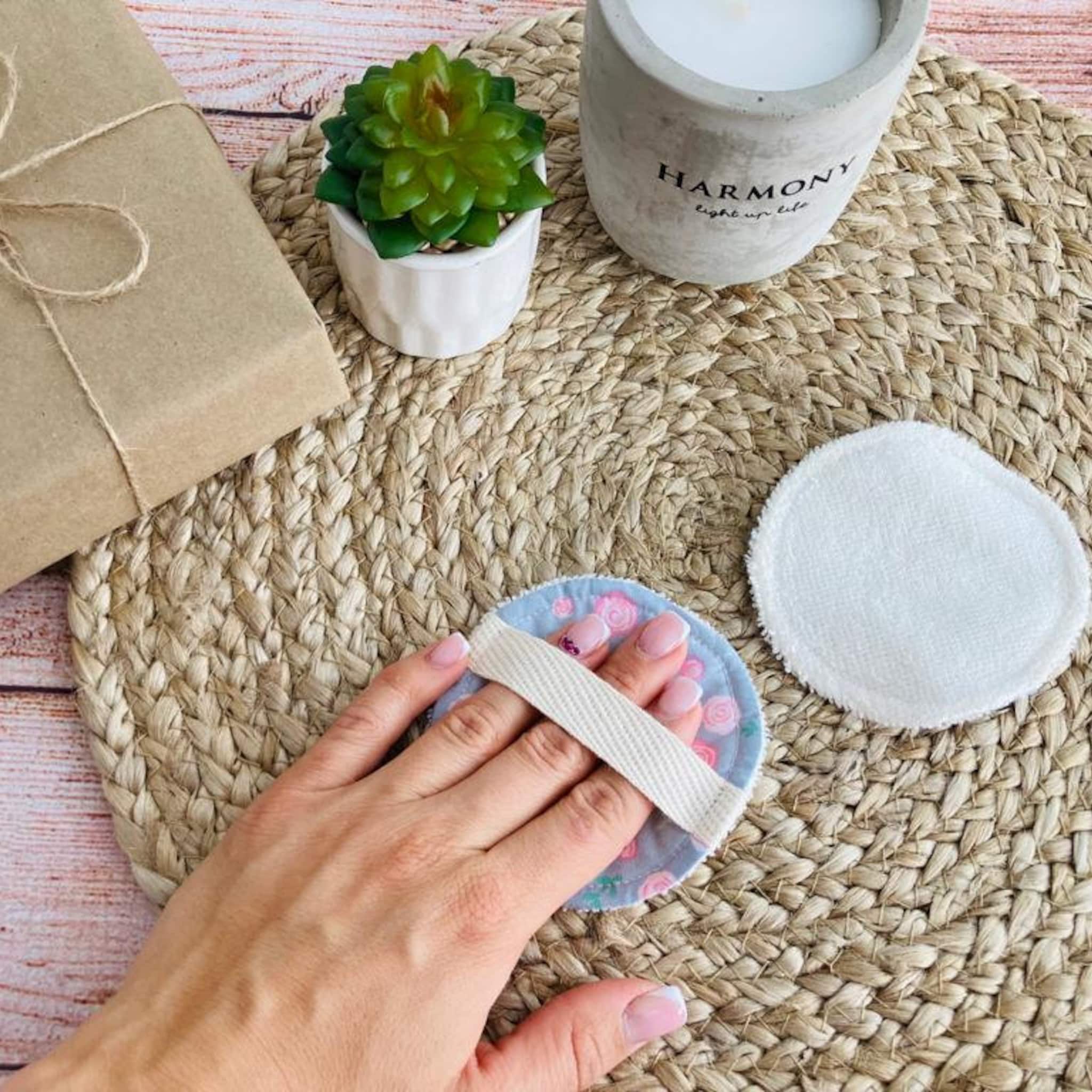 Reusable makeup remover pads, floral print fabric, white strap, and white terrycloth pads on woven mat