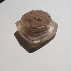Side view of loose mineral eyeshadow in matte brown shade with eco-friendly packaging and sifter dispenser