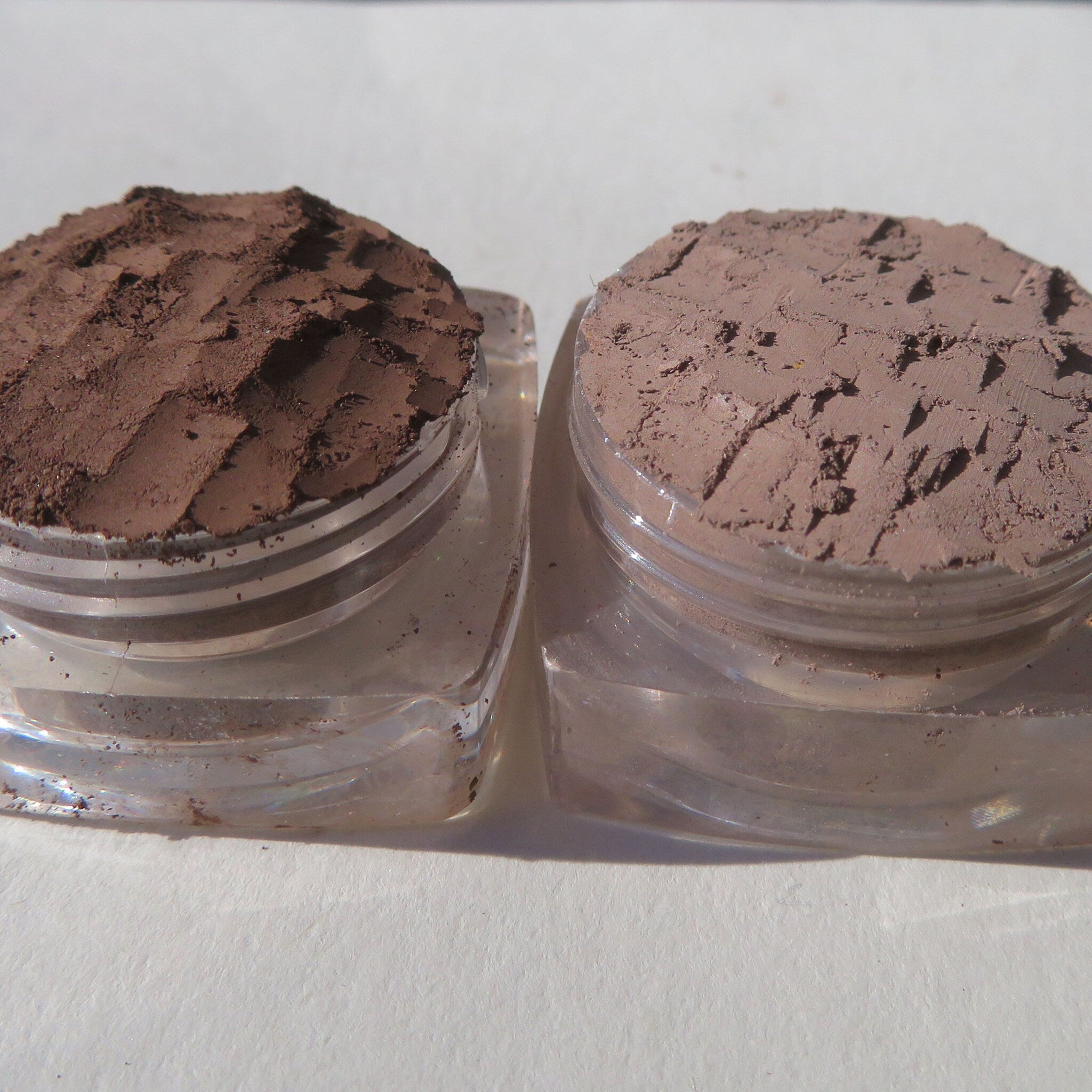 Close-up of matte brown loose pigment eyeshadow with fine mineral texture in open jar
