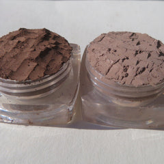 Close-up of matte brown loose pigment eyeshadow with fine mineral texture in open jar